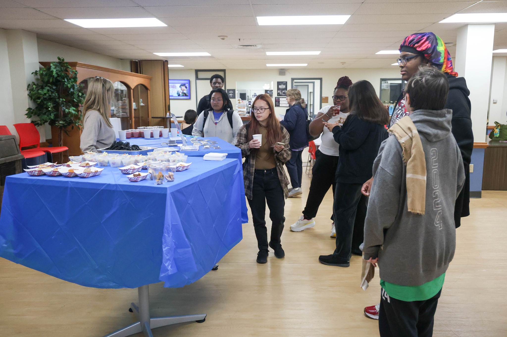 Group of people standing around table.
