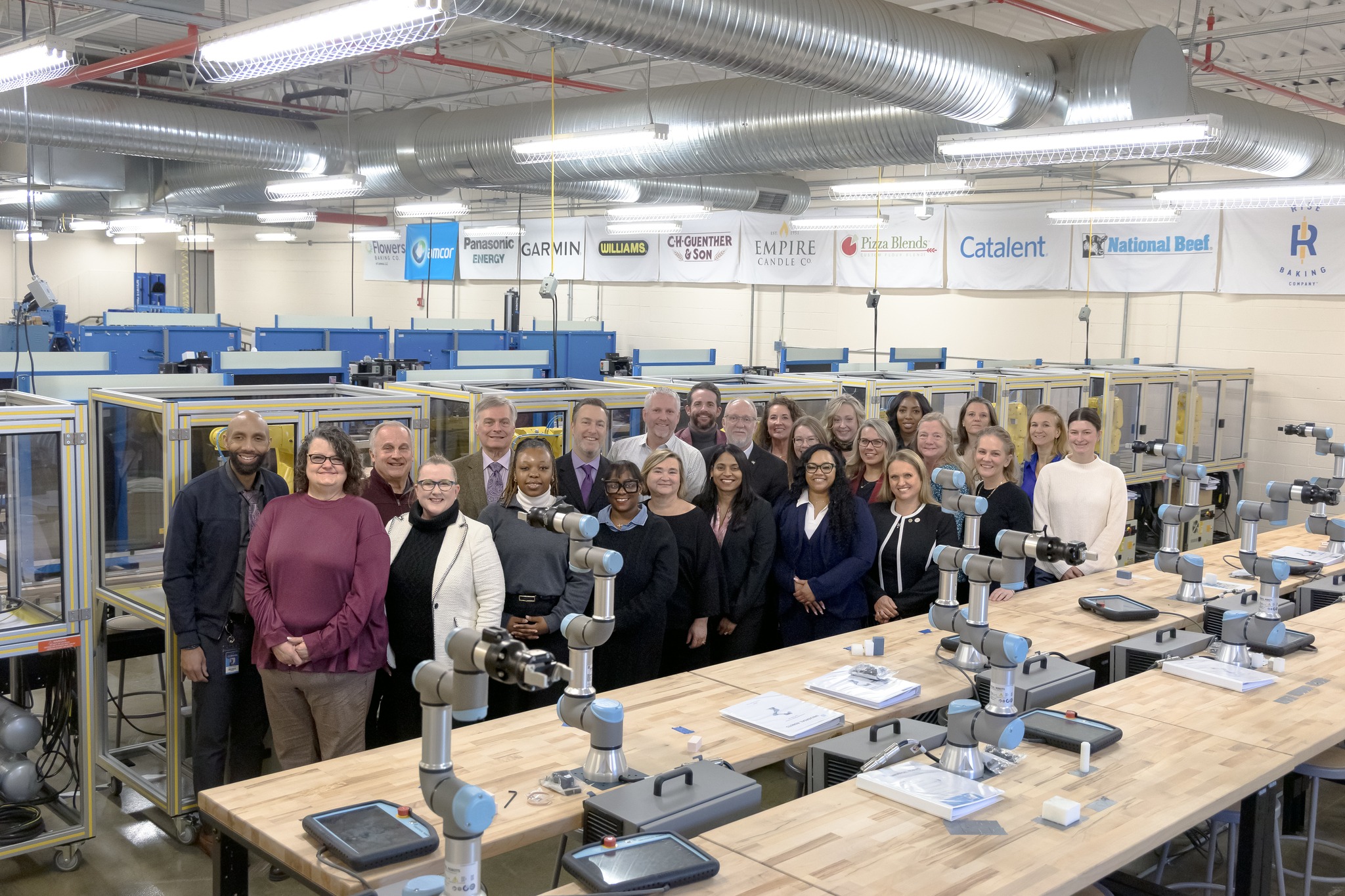 Group of people standing in technical education lab.