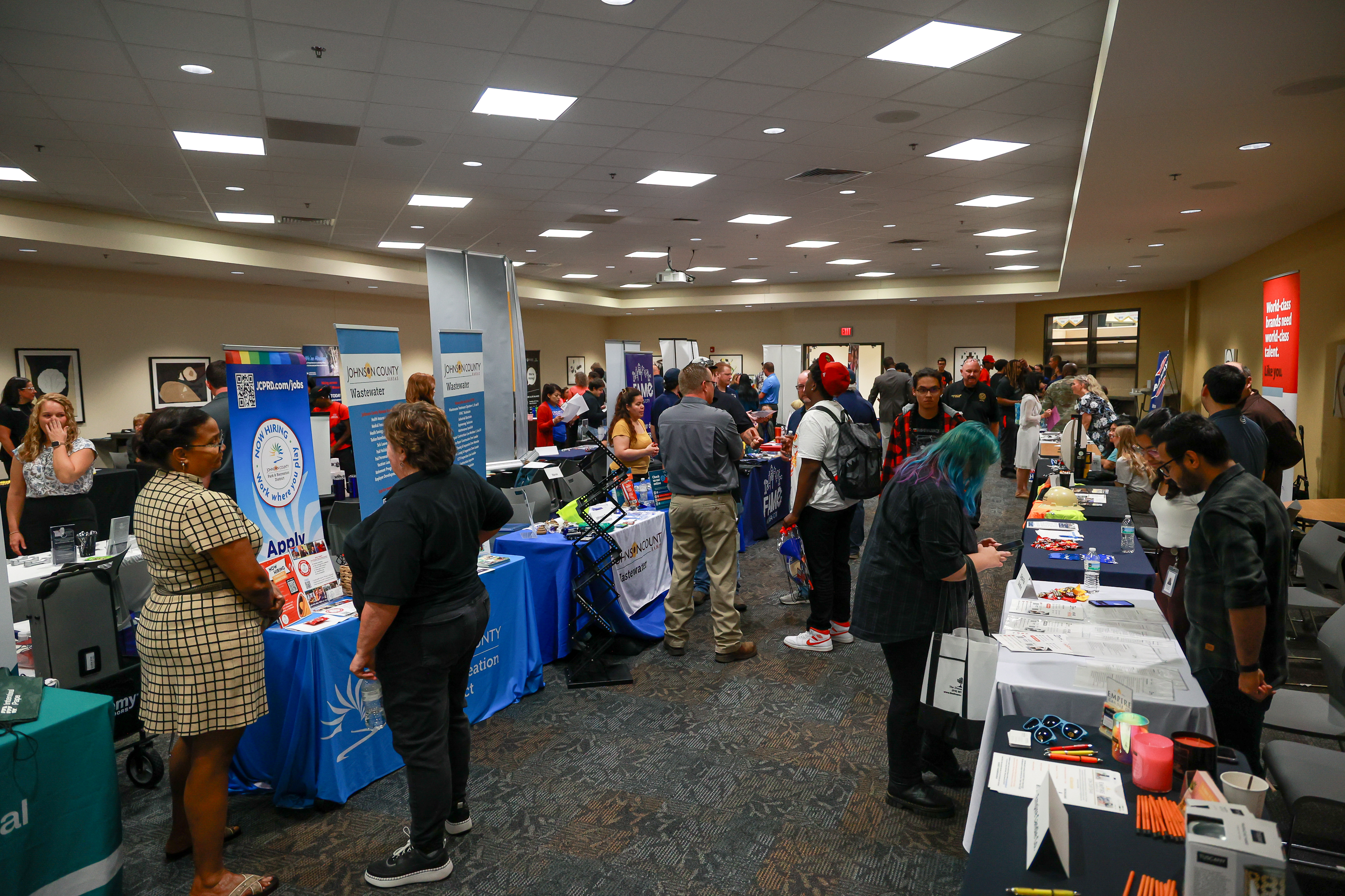People talking with employers in large room.