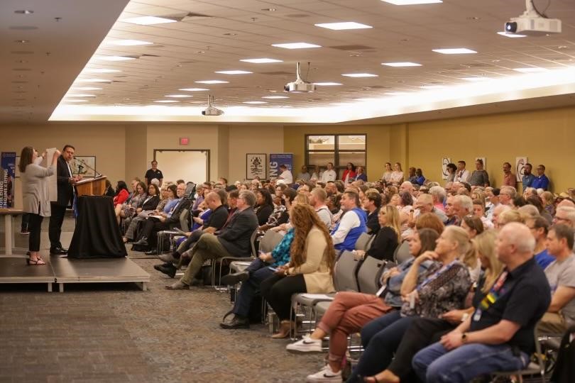 People sitting in a room listening to a speaker.