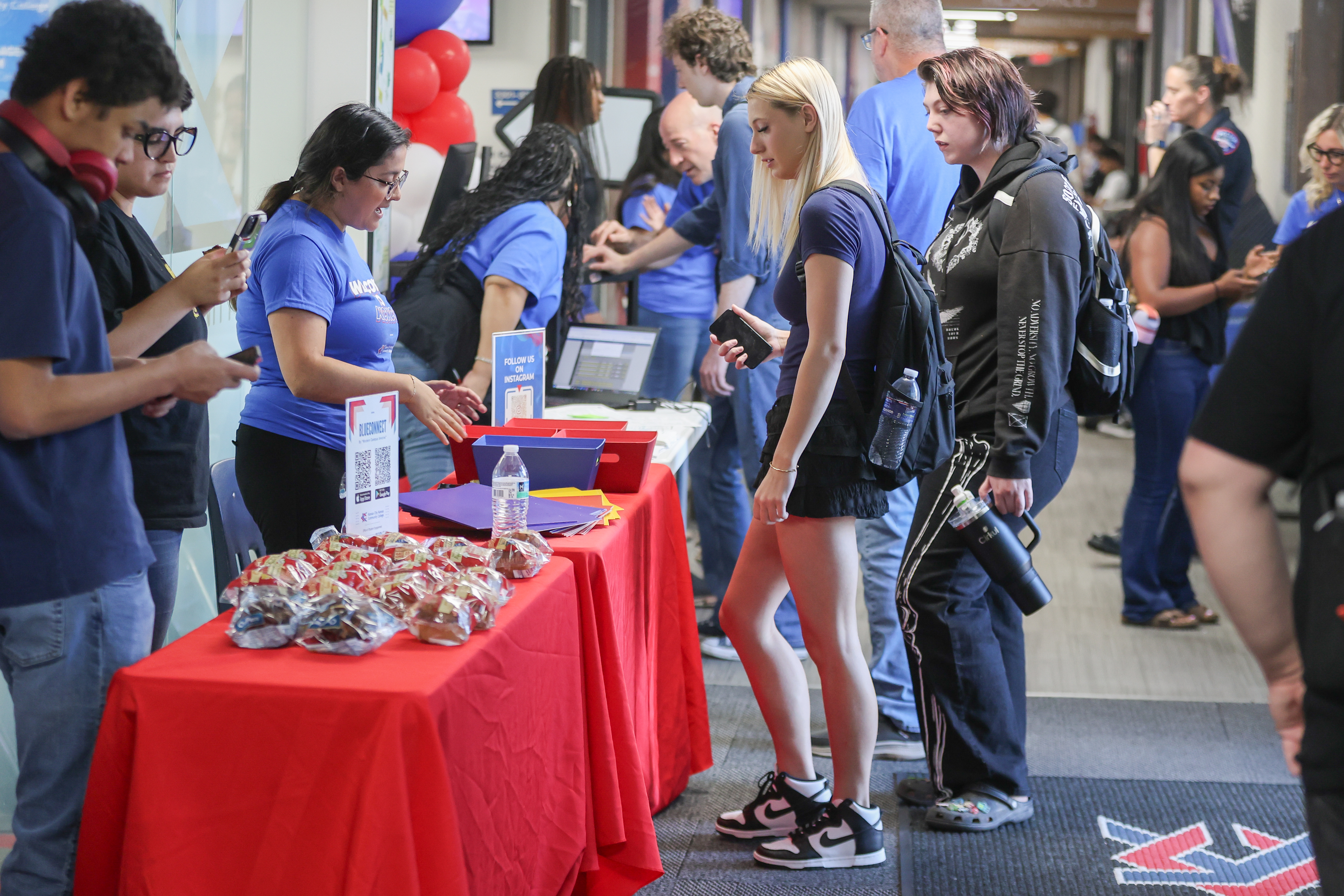 Students standing in front of table.
