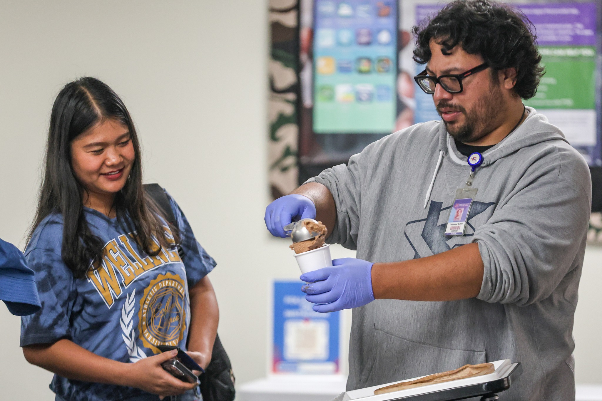 Man scooping ice cream for female student.