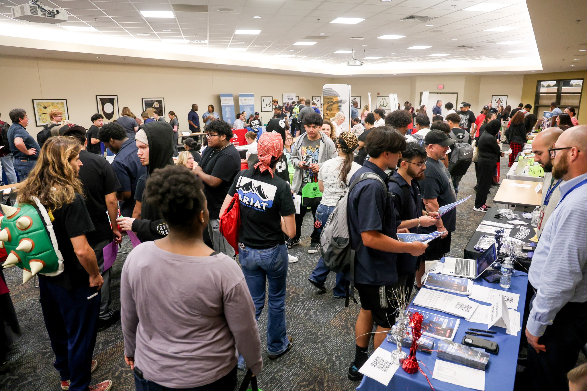 People walking among tables, speaking to employers.