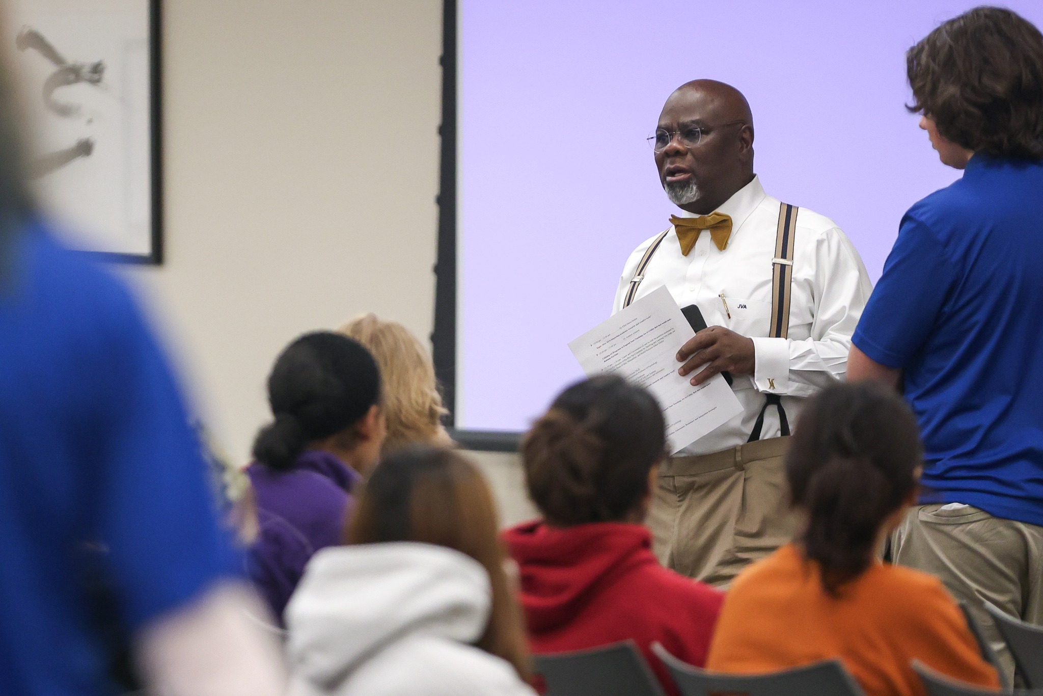 Man speaking in front of group of people.