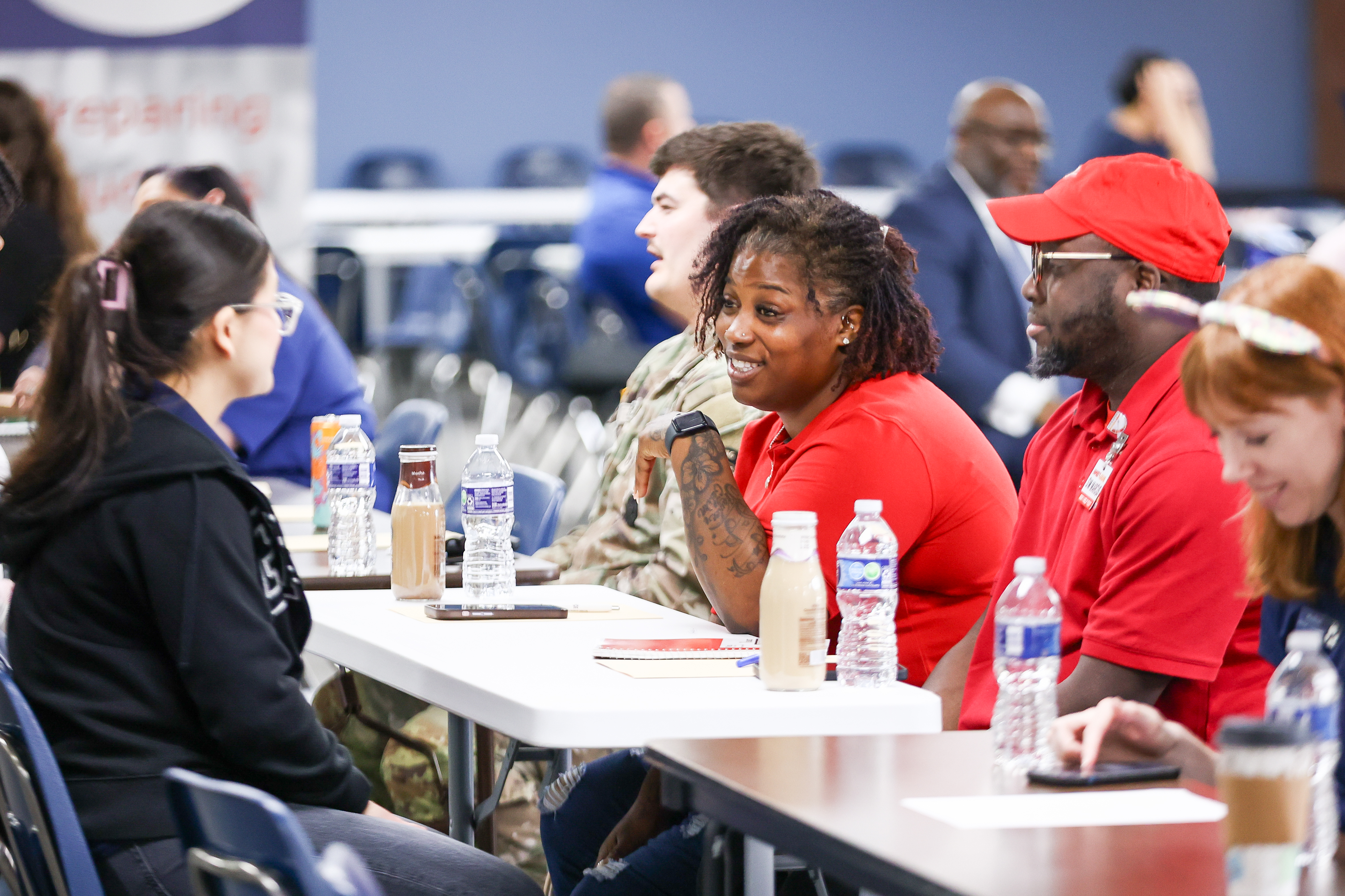 Woman in red t-shirt speaks to high school student.